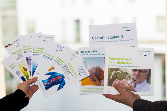 Informationsbroschüren des Kath. Klinikum Bochum werden hochgehalten